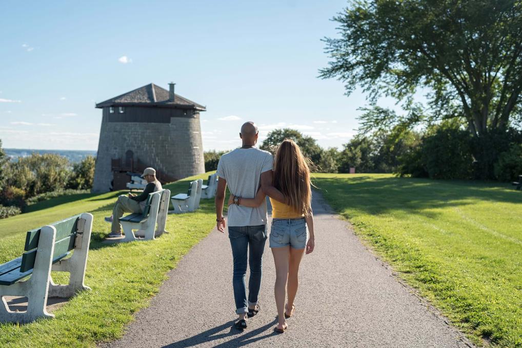 Couple amoureux marchant sur les plaines d'Abraham, en direction de la Tour Martello 1, en été.