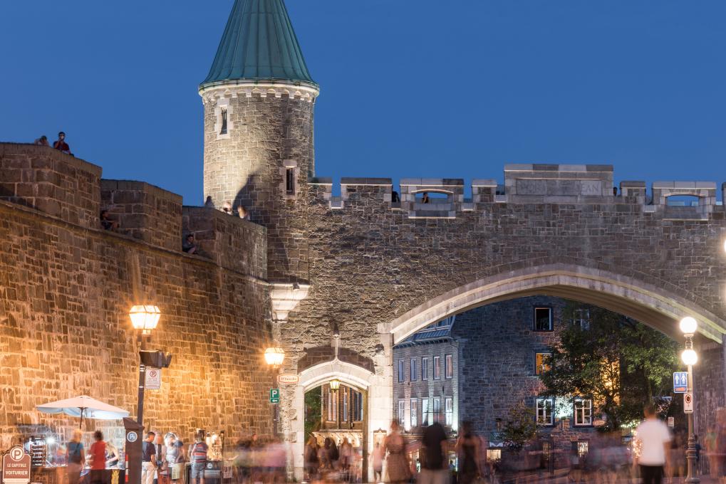 On a warm summer evening, visitors stroll along Saint-Jean Street, near Saint-Jean Gate.