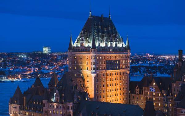 Vue aérienne du Fairmont Le Château Frontenac illuminé en soirée, l'hiver.