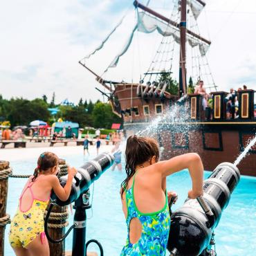 Des enfants s'amusent dans les jeux d'eau et le repaire des pirates au Village Vacances Valcartier.