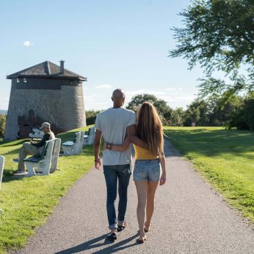 Couple in love walking on the Plains of Abraham, towards the Martello Tower 1, in summer.
